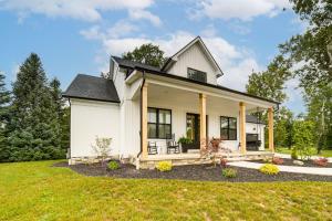 a small white house with a porch at Walk to Lake Erie Sleek Retreat with Screened Patio in Madison