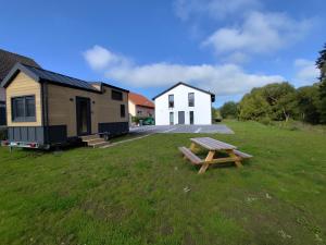 a picnic table in the grass in front of a tiny house at Dauny House - Dein Tiny House Erlebnis in der Vulkaneifel in Daun
