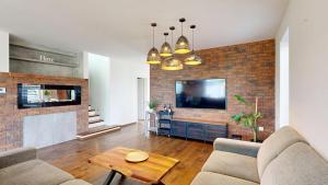 a living room with a brick wall with a tv at Exkluzívny rodinný dom Trnava - rodiny, pracovné cesty in Trnava