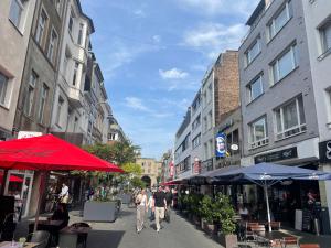 een groep mensen die door een straat lopen met paraplu's bij Premium Apartment 2 Cathedral in Keulen
