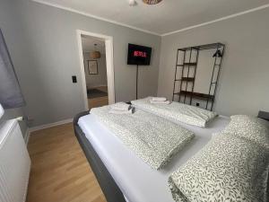 two beds in a room with a clock on the wall at Fundis Apartment am Schloss in Bad Harzburg