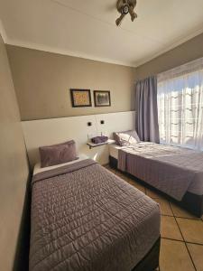 a hotel room with two beds and a window at ZUCH Accommodation at Pafuri Self Catering - Guest Apartment in Polokwane