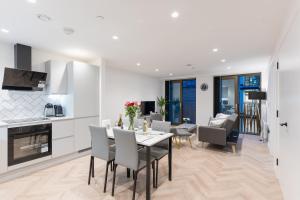 a kitchen and living room with a table and chairs at 2 Bed Apartment, in the heart of Manchester City Centre! 7 mins walk from Piccadilly Station! in Manchester