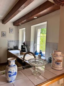 a kitchen with blue and white vases on a counter at Maison aux portes de Dijon à la campagne in Izier