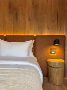 Un dormitorio con una cama blanca y una pared de madera. en Montano Boutique Suites, en El Calafate