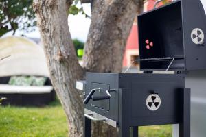 Una caja negra con un televisor frente a un árbol. en Villa Las Catedrales - Frente a la playa - Amplio jardín - Piscina, en Barreiros 40 fotos más