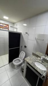 une salle de bains avec toilettes et lavabo dans l'établissement Casa de Praia Guriri, à São Mateus 25 autres photos