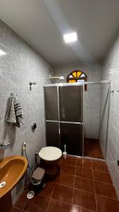 une salle de bains avec douche, lavabo et toilettes dans l'établissement Casa de Praia Guriri, à São Mateus