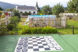 Un tablero de damas sobre un tablero de ajedrez en un patio en Villa Las Catedrales - Frente a la playa - Amplio jardín - Piscina, en Barreiros