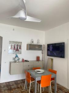 ベルヴェデーレ・マリッティモにあるVilla a Diamante Sulla Spiaggiaのダイニングルーム(テーブル、オレンジチェア付)