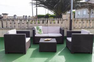 un patio con 2 sillas, un sofá y una mesa en Villa Las Catedrales - Frente a la playa - Amplio jardín - Piscina, en Barreiros