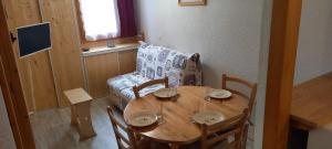 a wooden table with chairs and a couch in a room at Appartement à Montchavin in La Plagne Tarentaise
