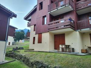 a building with red doors and a stone wall at Appartement à Montchavin in La Plagne Tarentaise