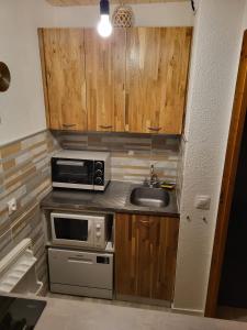a small kitchen with a sink and a microwave at Appartement à Montchavin in La Plagne Tarentaise