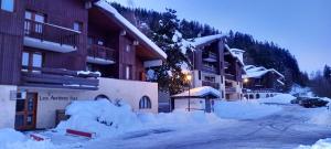 a street covered in snow in front of buildings at Appartement à Montchavin in La Plagne Tarentaise +1 photo