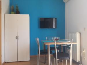 a dining room with a table and chairs and a blue wall at Apartment Murtila in Kaštela
