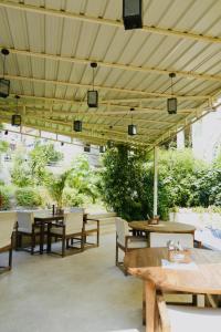 a patio with tables and chairs and a wooden ceiling at Yogi Resort And Garden Cafe in Rishīkesh +23 photos