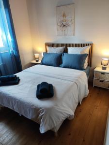 ein Schlafzimmer mit einem großen weißen Bett mit blauen Kissen in der Unterkunft L'Adonis - Family home near Equiblues WIFI in Saint-Agrève
