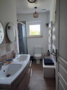 ein Badezimmer mit zwei Waschbecken und einer Toilette und einem Fenster in der Unterkunft L'Adonis - Family home near Equiblues WIFI in Saint-Agrève + 18 Fotos