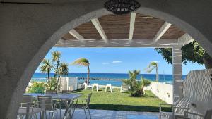 a patio with a table and chairs and the ocean at Villa a Diamante Sulla Spiaggia in Belvedere Marittimo