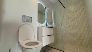 ein weißes Badezimmer mit Toilette und Dusche in der Unterkunft Velora Apartments in Năvodari + 45 Fotos