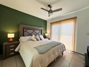 a bedroom with a large bed with a green wall at Casa Olivo in Yautepec