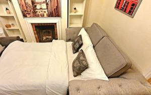 a bed with two pillows on it in a room at Windsor Castle amazing Cottage in Windsor