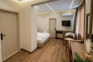 カイロにあるNefri Pyramids Hotelのベッドと机とテレビがあるホテルの部屋