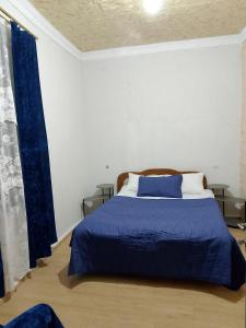 a bedroom with a bed with a blue comforter at Sweetnight apartments in Mestia
