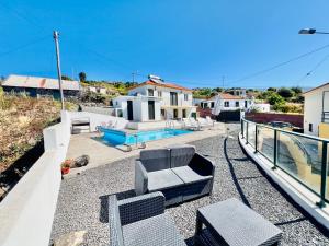 una casa con patio con sillas y piscina en Casa Maria Cottage with Sea View, en Estreito da Calheta