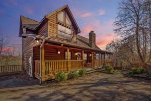 a large wooden house with a porch at Little Cub Cabin I Spacious Exquisite View 3 King Hot Tub & BBQ in Sevierville