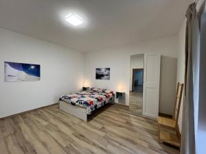 una camera bianca con un letto e un corridoio di Casale Don Minzoni a Misterbianco