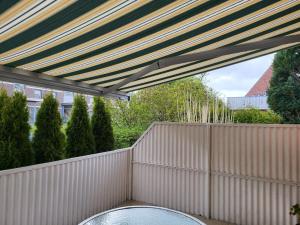 a patio with a white fence and a table at BUE - Friesenwinkel in Büsum +4 photos
