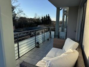 a balcony with a couch and a view of a city at Alpen Apartman Freilassing in Freilassing