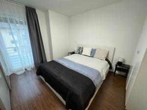 a bedroom with a bed and a large window at Alpen Apartman Freilassing in Freilassing