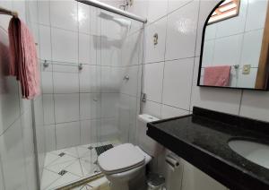 a bathroom with a toilet and a sink and a mirror at Casa com suítes privativas - Localização no centro, perto de serviços e pontos turísticos in Belém