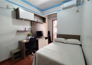 a bedroom with a bed and a desk with a computer at Casa com suítes privativas - Localização no centro, perto de serviços e pontos turísticos in Belém