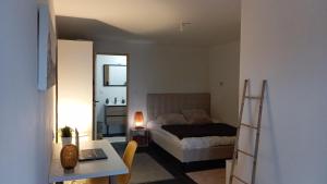a small bedroom with a bed and a desk and a table at Chalet vue panoramique in Fillinges