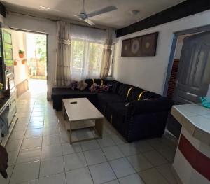 a living room with a black couch and a table at Masai 4 in Diani Beach