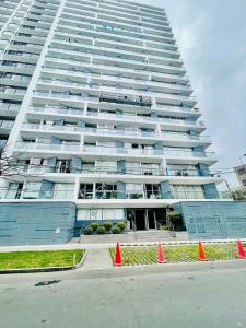 a tall building with orange cones in front of it at Habitaciones privadas con vistas al parque in Lima