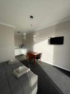 a bedroom with a bed and a table and a television at Empire Cafe & Accommodation in Kumara