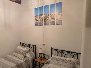 a bedroom with two beds and a picture on the wall at La Muralla in Villajoyosa
