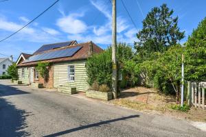 une maison avec des panneaux solaires sur le toit dans l'établissement Olive Tree Cottage, à Rye