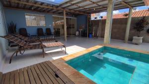 a swimming pool with a table and chairs on a patio at Edicula Brotas in Brotas