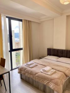 une chambre avec un lit et une grande fenêtre dans l'établissement Sweet Apartment For Daily Rent, à Tbilissi