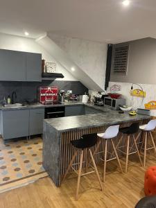 a kitchen with a counter and some bar stools at 1930 house in La Marbellière, 2 bedrooms in Joue-les-Tours