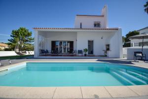 a villa with a swimming pool in front of a house at Marisol Village in Corroios