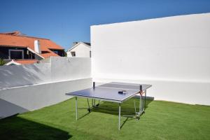a ping pong table on a lawn in a backyard at Marisol Village in Corroios