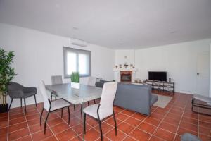 a dining room with a table and chairs and a couch at Marisol Village in Corroios