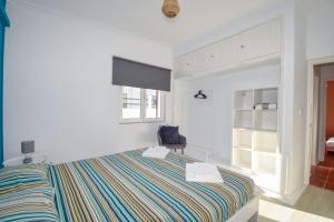 a white bedroom with a bed and a chair at Marisol Village in Corroios +51 photos